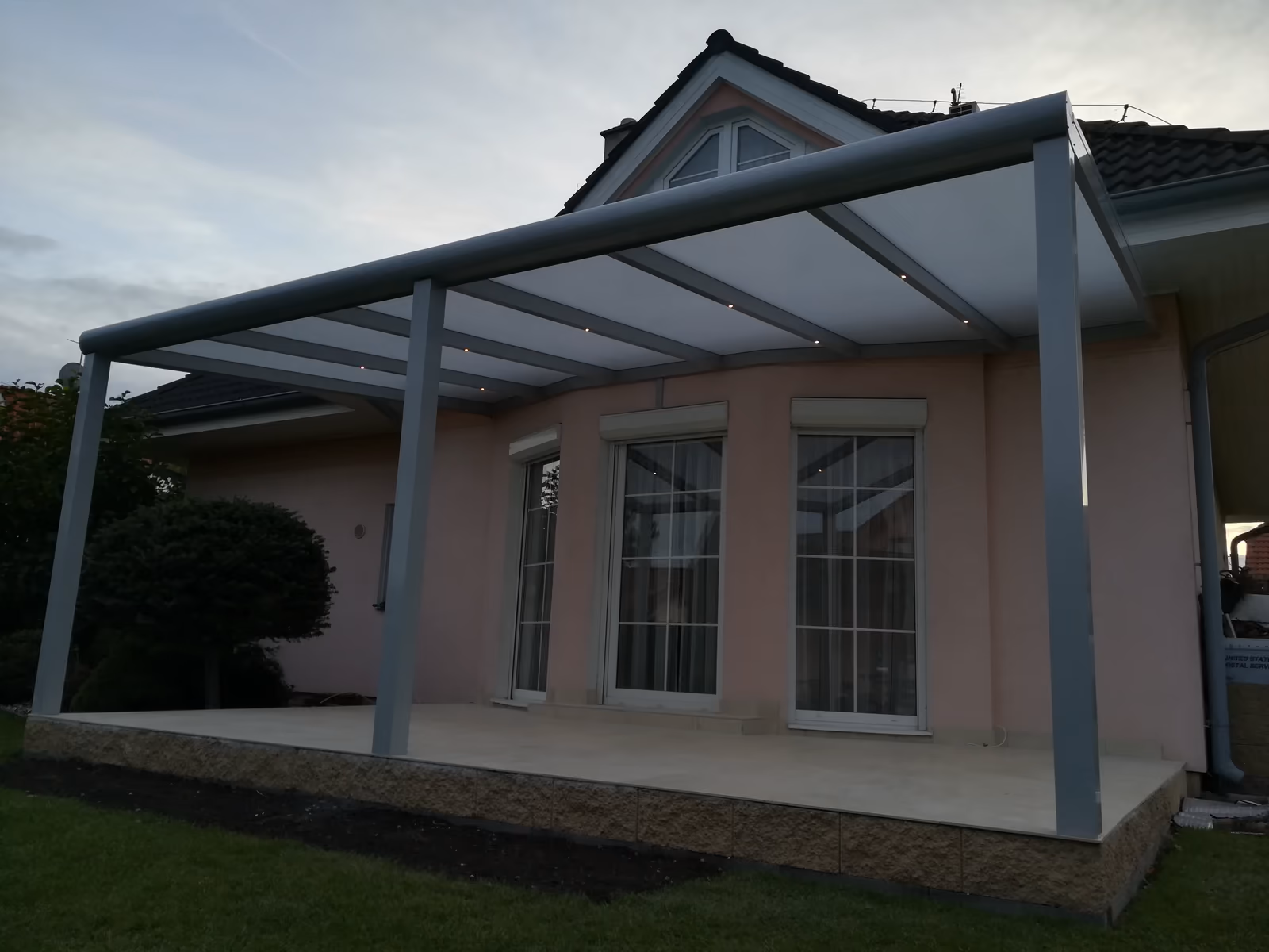 šedá hliníková pergola s LED nad terasou u meruňkového domu