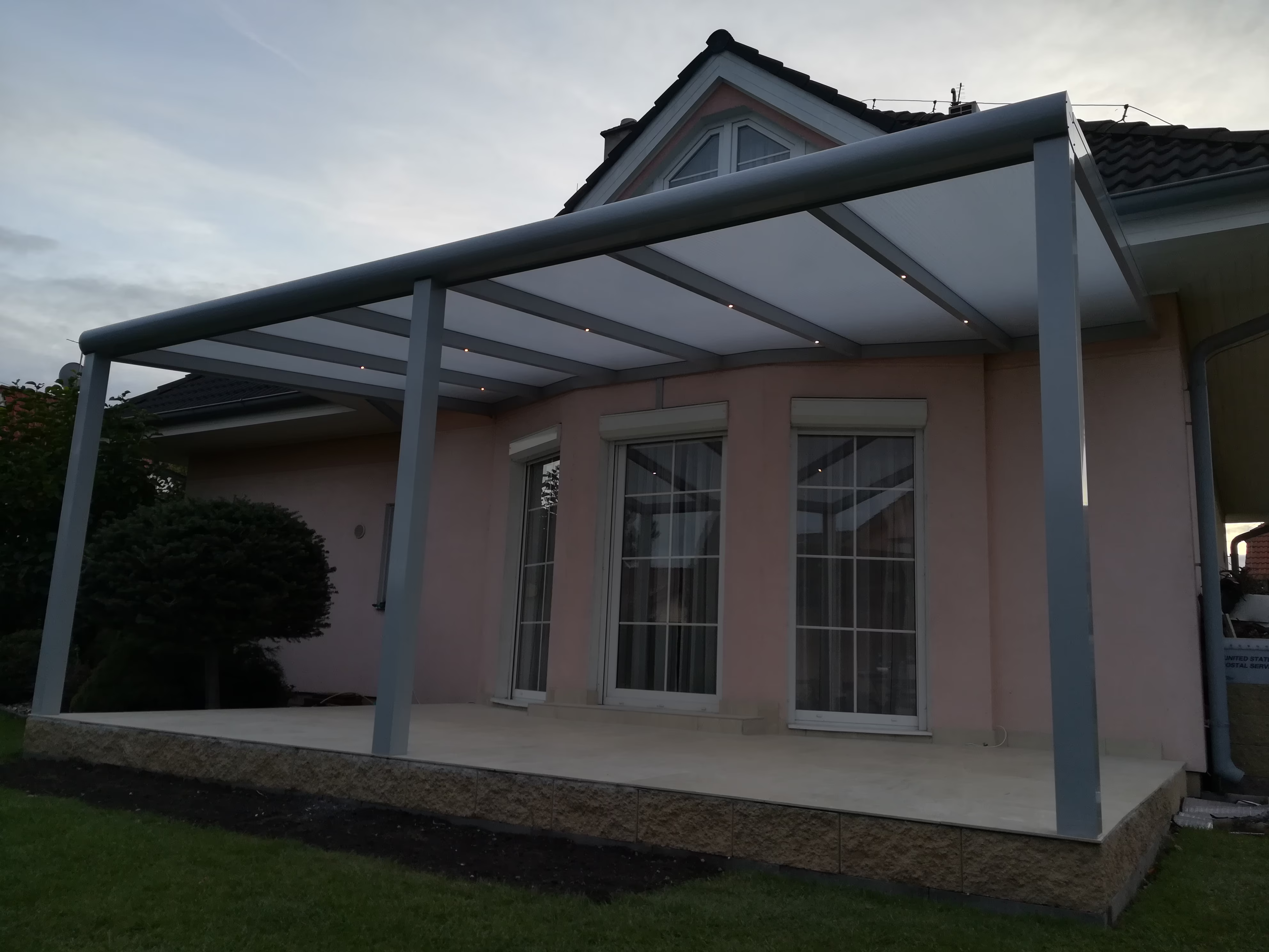 šedá hliníková pergola s LED nad terasou u meruňkového domu